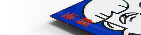 Eine blau-orangefarbene Schachtel mit chinesischer Schrift darauf und einem Rahmen oder Glas-Bildträger.