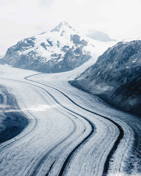 Ein atemberaubendes Bild, das die Majestät des Aletschgletschers mit einem Berg im Hintergrund zeigt.