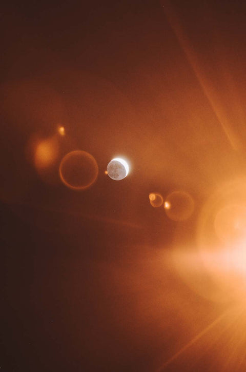 Verdunkelung des Astrolabiums mit Lens Flare-Effekt und dem Mond im Hintergrund.