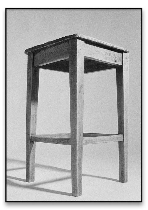 Eine Schwarz-Weiß-Fotografie eines Stuhls mit Gebrauchsspuren.