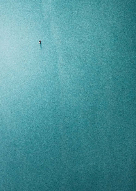 Eine Person schwimmt in einem blauen Gewässer, umgeben von Das Boot.