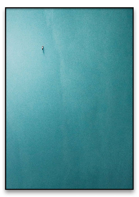 Eine Person schwimmt im blauen Wasser, umgeben von Das Boot.