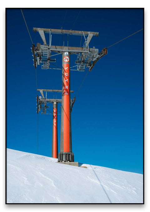 Ein Skiliftmast auf einer verschneiten Schneelandschaft.
Produktname: Der Masten trägt Prada