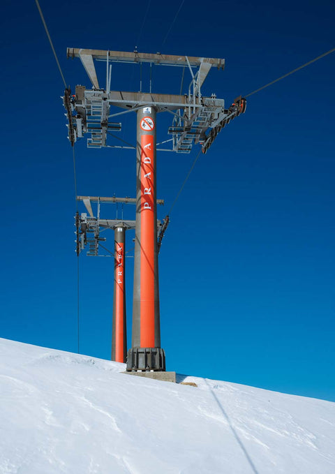 Ein Skiliftmast auf einer verschneiten Schneelandschaft trägt Prada.