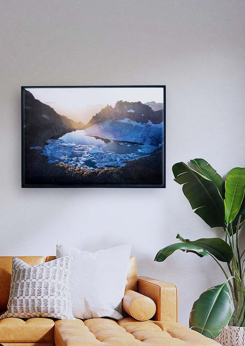 Ein Wohnzimmer mit einem Fernseher, der über einer Couch hängt und ein Gletschersee-Panorama bietet.