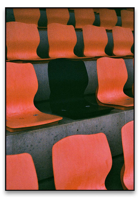 Eine Reihe von orangefarbenen ImStation-Stadionsitzen in einem Stadion.