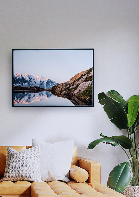 Ein Wohnzimmer mit einem Mont Blanc an der Wand, auf dem ein lebendiges Naturfoto zu sehen ist.