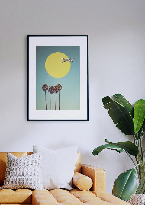 Ein Wohnzimmer mit einem gerahmten Druck einer gelben Sonne und Palmen.