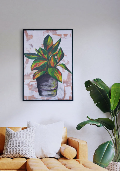 Ein Wohnzimmer mit einer Planta, die über einer Couch hängt, und einer Grün-Malerei an der Wand.