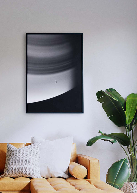 Eine Fotografie von Saturn in Schwarz-Weiß, die über einem Raum in einem Wohnzimmer hängt.