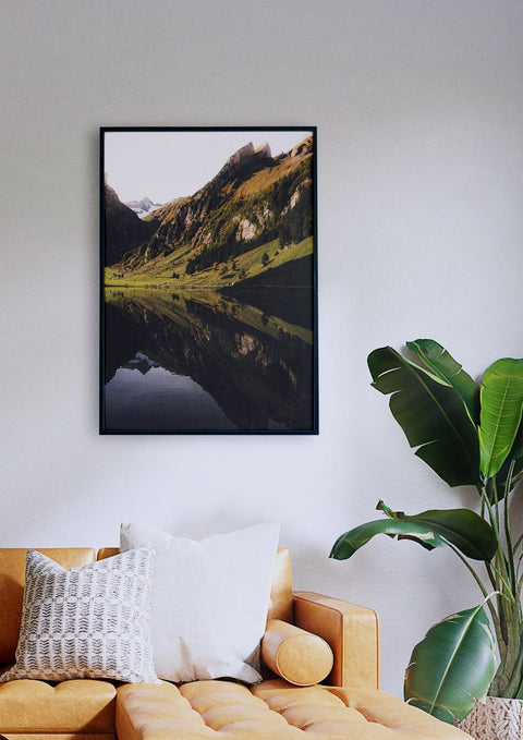 Ein Wohnzimmer mit einer Couch und einem gerahmten Bild vom Seealpsee, das die Schönheit der Natur widerspiegelt.