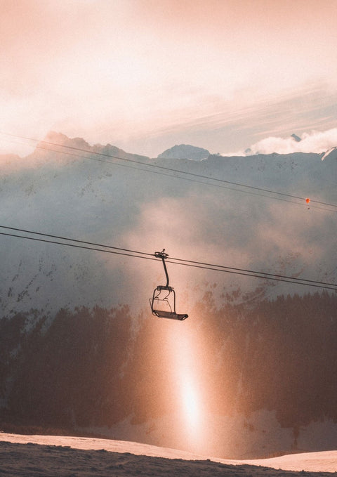 Ein Skilift in den Bergen beim Sonnenuntergang.