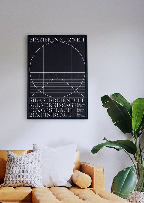 Ein Wohnzimmer mit einer Couch „Spazieren zu zweit“ und einem Poster an der Wand mit Schwarz-Weiss Grafik Design.