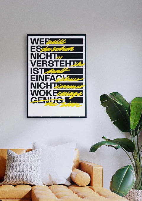 Ein Wohnzimmer mit einer Couch und einem schwarz-gelben Poster von „Wer es nicht versteht“ auf einem schwarzen Hintergrund.