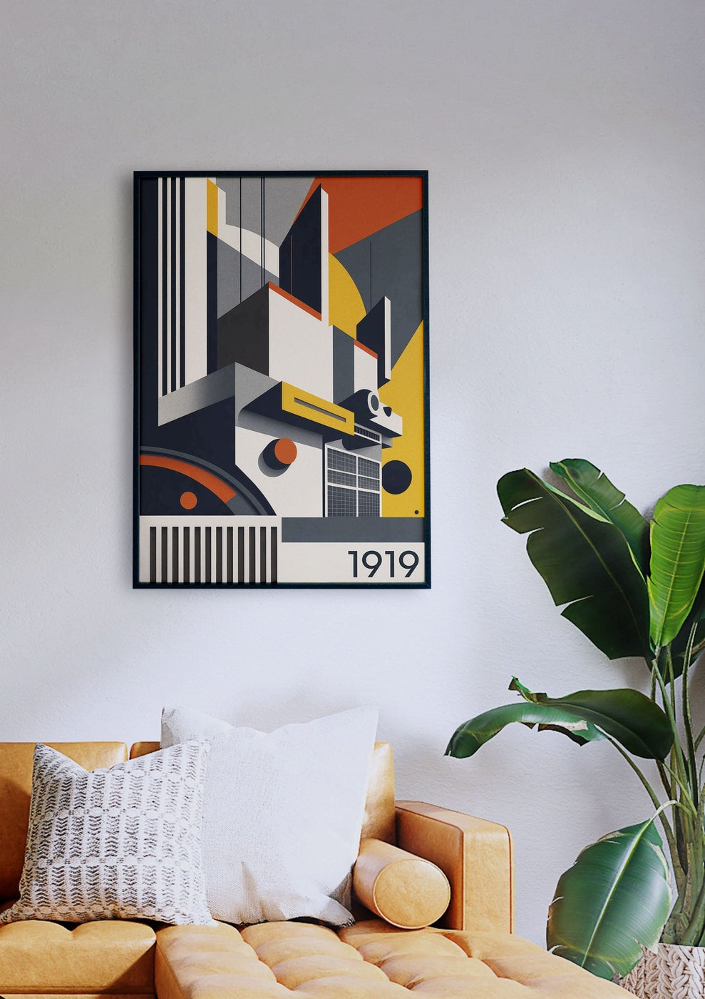 Der geometrische abstrakte Kunstdruck „Bauhaus-Gebäude 2“ mit der Jahreszahl „1919“ hängt elegant an einer weißen Wand über einem senfgelben Sofa mit weiß-grau gemusterten Kissen neben einer grünen Pflanze.