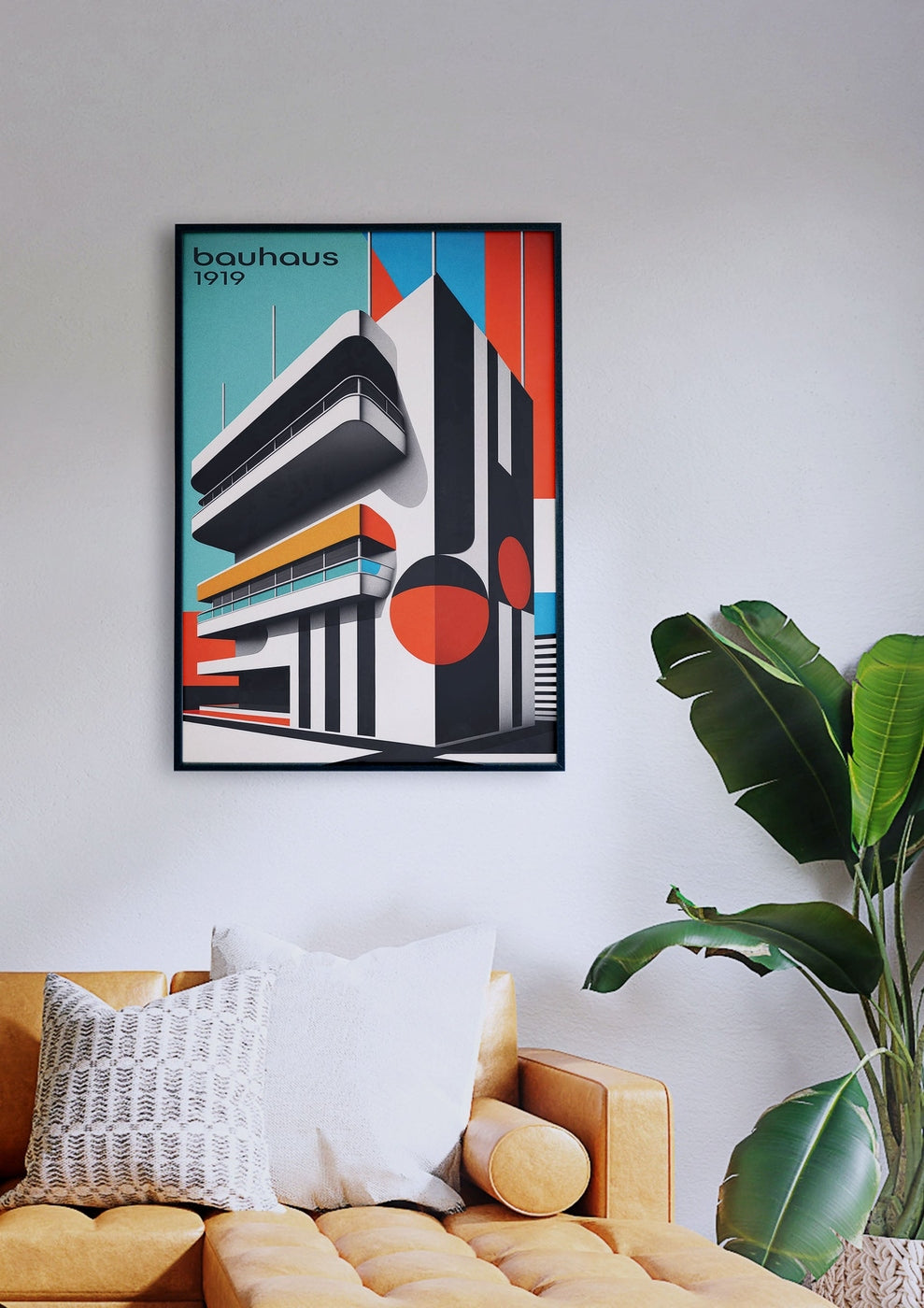 Gerahmtes Bauhaus-Gebäude 4-Poster an einer weißen Wand über einem gelben Sofa mit Kissen. Rechts neben dem Sofa steht eine grüne Pflanze.