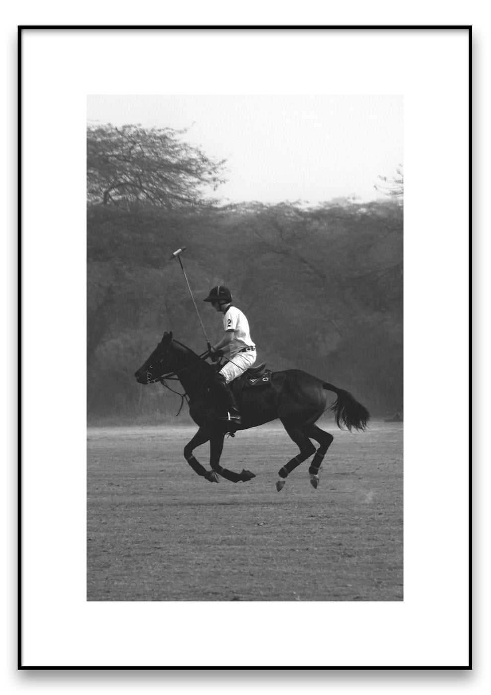 Ein Schwarzweißfoto mit dem Titel „Polo“ zeigt einen Polospieler, der mit einem Schläger in der Hand auf einem galoppierenden Pferd auf einer Wiese mit Bäumen im Hintergrund reitet.