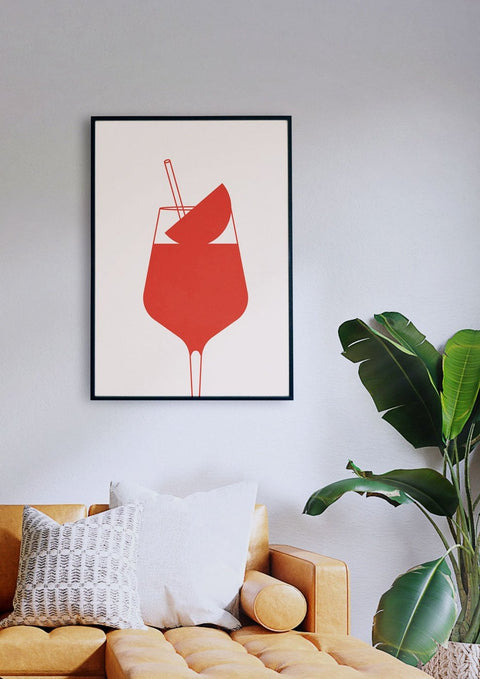 Eine Malerei eines roten Cocktails in einem Glas, das über einer Couch hängt, SPRITZ PLEASE.