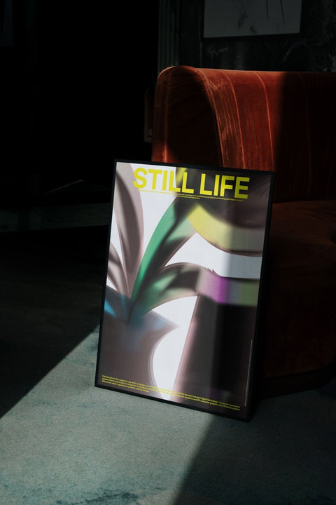 Ein gerahmtes Poster mit der Aufschrift „Still Life“ in 3D-Rendering-Typografie darauf.