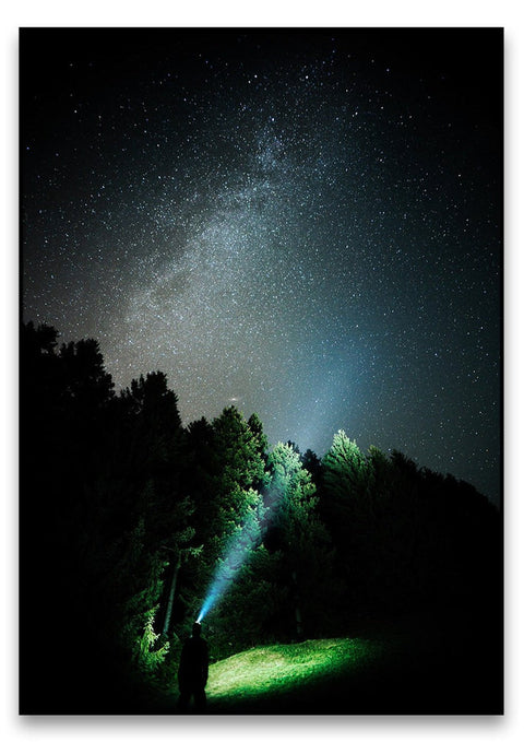 Eine Person steht mit einer Taschenlampe unter einem Sternenhimmel, umgeben von Sternenstaub und Gian Reichmuth Artists.