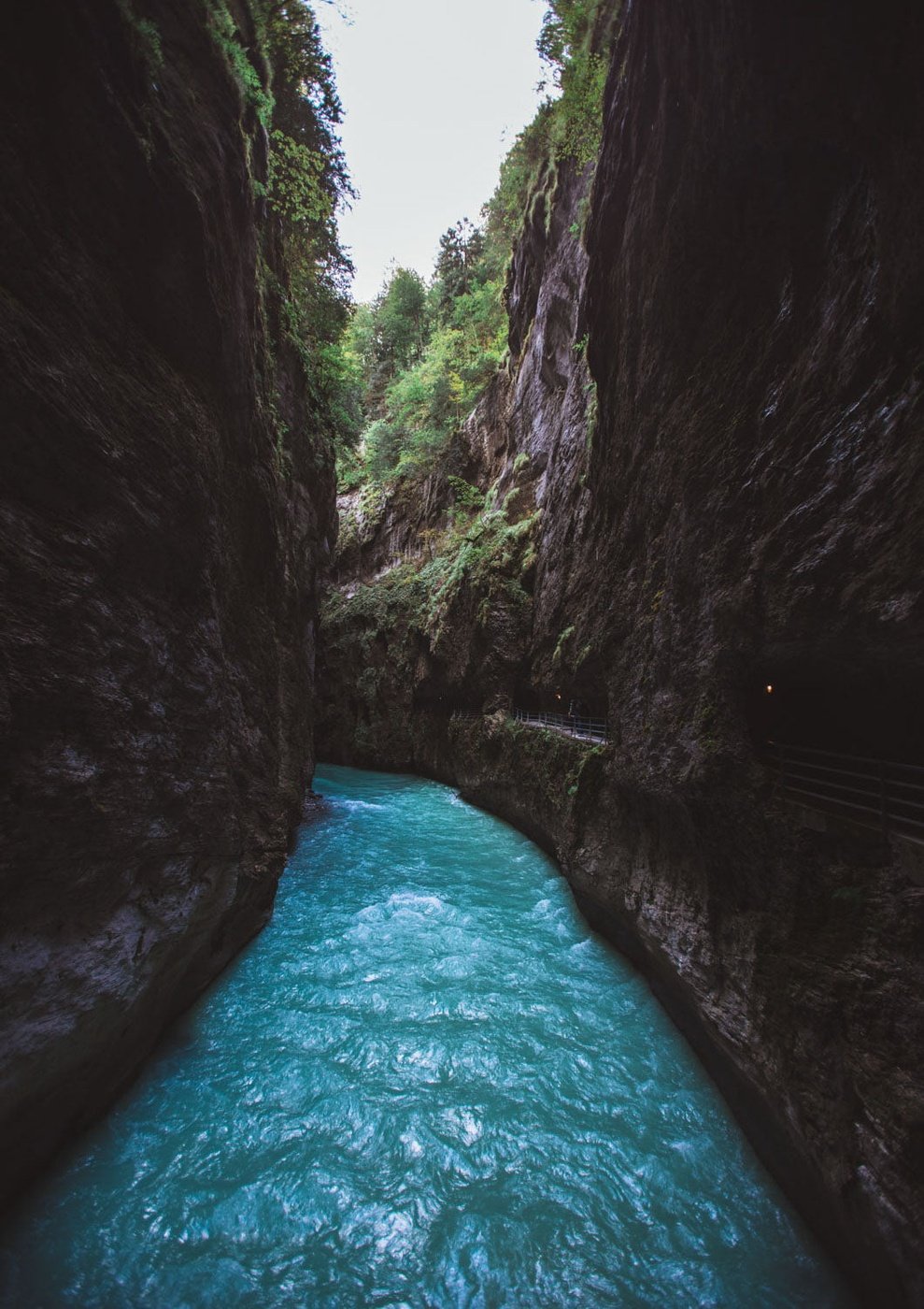 Ein blauer Swiss Canyon Fluss fließt durch eine Schlucht.