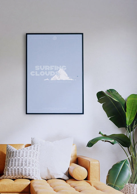 Ein Wohnzimmer mit einer Couch und einem gerahmten Poster mit dem Bild eines Wolkensurfers.