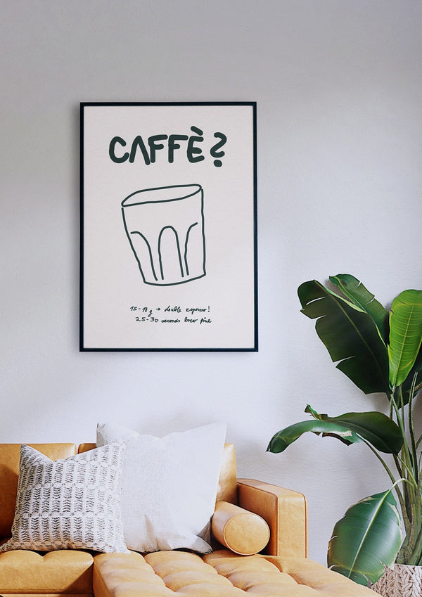 Ein minimalistisches Wohnzimmer mit einem senfgelben Sofa, weißen und gemusterten Kissen, einer Topfpflanze und dem gerahmten „Caffè?“-Poster (Off White) an der Wand, das die Skizze einer Tasse mit fettem Text zeigt.