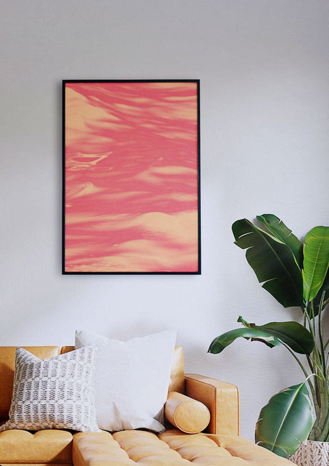 Ein rosa abstraktes Gemälde mit rotem Meer 01, das über einer Couch in einem Wohnzimmer hängt.
