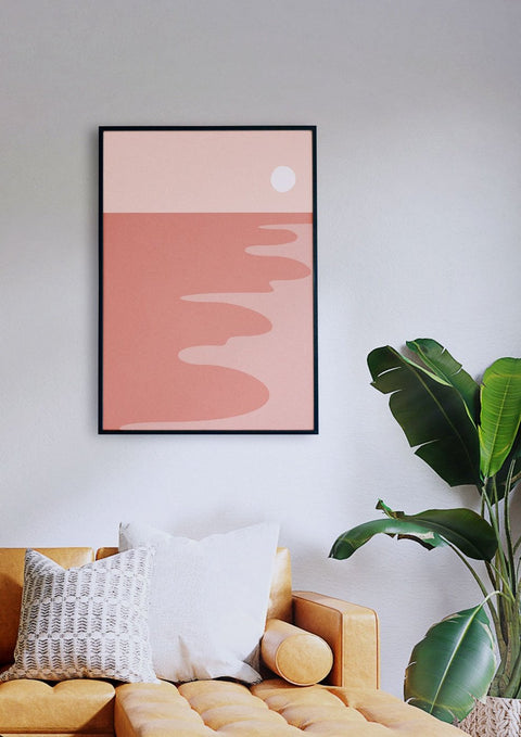 Ein Wohnzimmer mit einer Couch und einem rosa Sonnenuntergangsgemälde an der Wand.