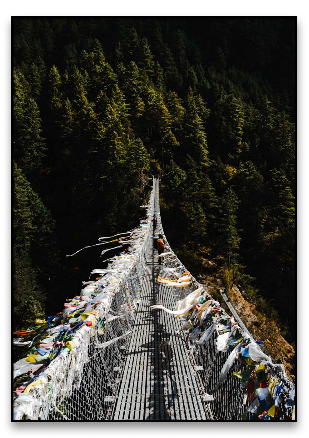 Eine mit bunten Gebetsfahnen geschmückte Hängebrücke, die die künstlerische Kreativität der Acrophobia-Künstler zeigt.