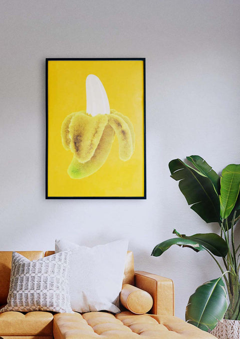 Eine gelbe Banane hängt über einem Sofa in einem Wohnzimmer, wo verdienende Künstler ihre Kunstwerke präsentieren, die von Qualitätsdruckereien in höchster Qualität gedruckt wurden.