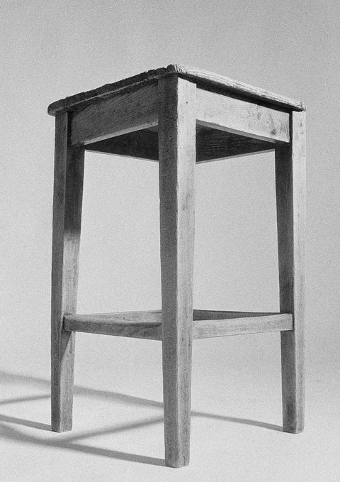 Ein Schwarz-Weiß-Foto eines Holzstuhls, aufgenommen von Qualitätsdruckereien.