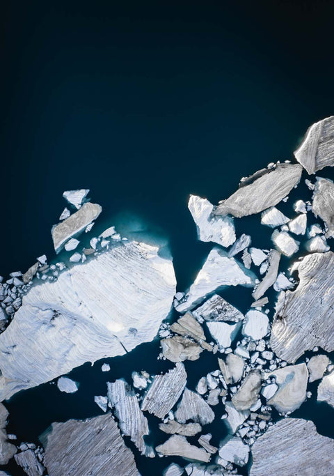 Ein Luftbild von Eisbergen, die im Wasser treiben.