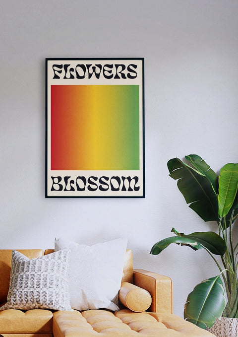 Ein Wohnzimmer mit einer Couch und einem Poster mit der Aufschrift „Flowers Blossom“ in Typografie.