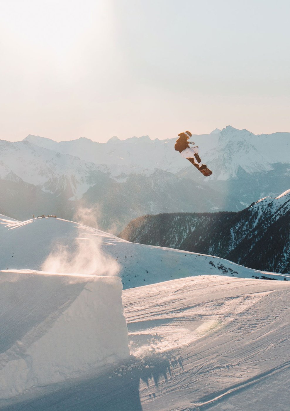 Ein Jatzpark in der Luft über einer schneebedeckten Winterlandschaft.