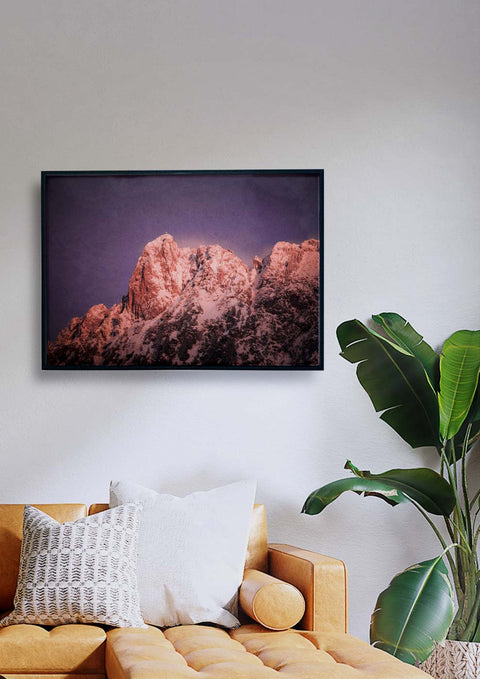 Ein Wohnzimmer mit Couch und Kamin, mit einer Kleiner Mythen-Fotografie der Berge.