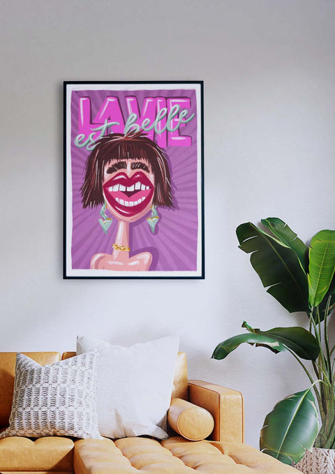 Ein Wohnzimmer mit einer lila Couch und einem La Vie est belle-Mund einer Frau.