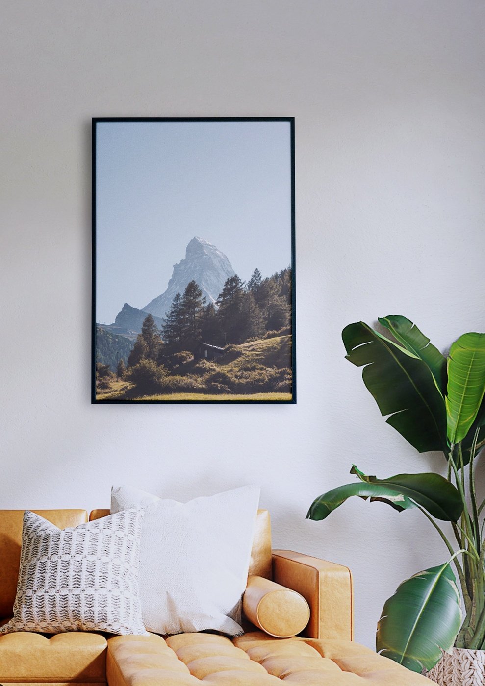 Ein Wohnzimmer mit einer Couch und einem Bild der Matterhornlandschaft.