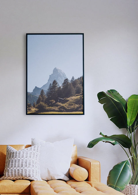 Ein Wohnzimmer mit einer Couch und einem Bild der Matterhornlandschaft.