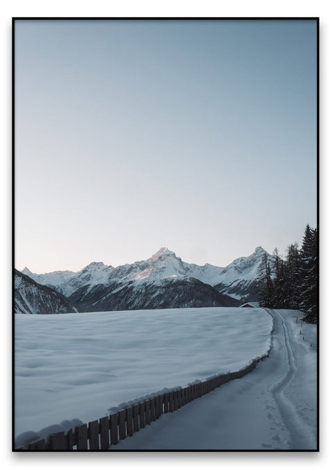 Eine Winterlandschaft mit einem von der Schmittner Alp bedeckten Weg und Bergen im Hintergrund.