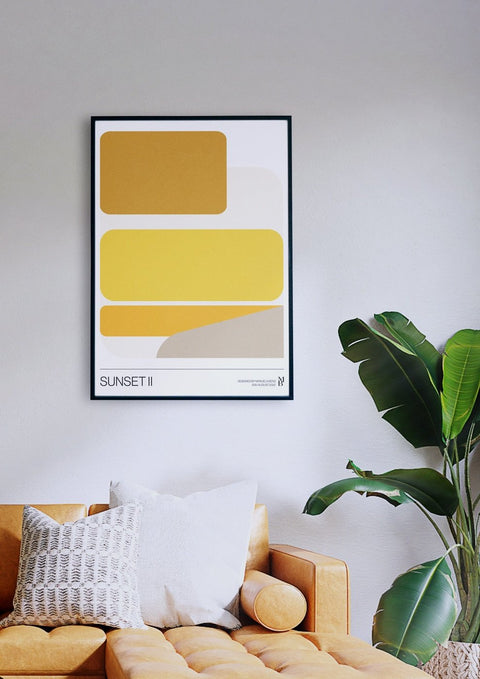 Ein Wohnzimmer mit einer gelben Couch und Wandkunst im Sunset II-Stil.