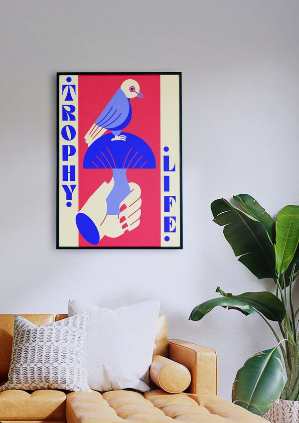 Ein Wohnzimmer mit einer blauen TrophyLife-Couch und einem Vogel darauf, dessen Design in leuchtenden Farben gehalten ist.