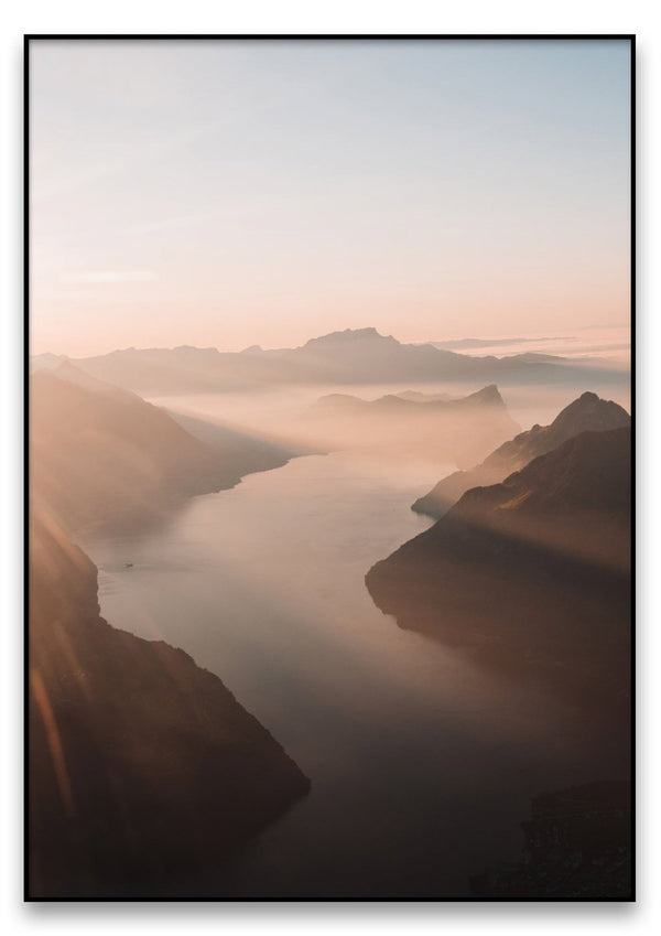 Eine Gebirgslandschaft bei Sonnenaufgang mit dem Vierwaldstättersee im Vordergrund.