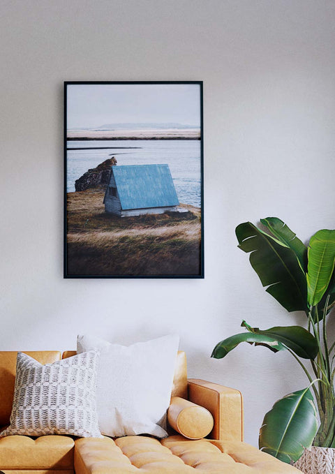 Eine Couch im Wohnzimmer mit einem Bild eines Bootes in einer Villa am Meer an der Wand.