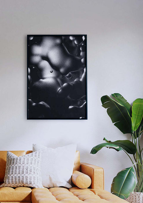 Ein Schwarz-Weiß-Foto, das als Wasserblase gilt und über einer Couch in einem Wohnzimmer hängt.