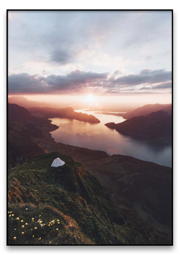 Ein Woke up like this auf einem Berggipfel, das eine Landschaft mit einem See überblickt.